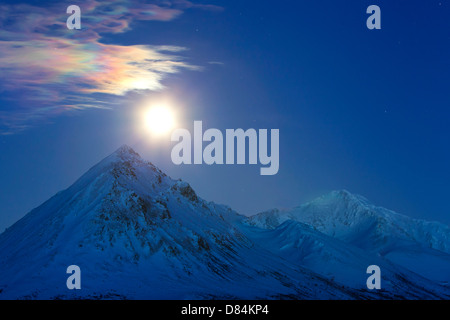 Full moon with rainbow clouds over Ogilvie Mountains, Tombstone Park, Dempster Highway, Canada. Stock Photo