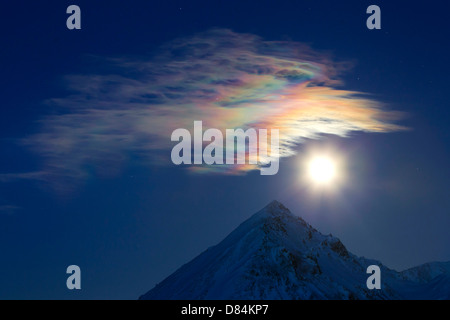 Full moon with rainbow clouds over Ogilvie Mountains, Tombstone Park, Dempster Highway, Canada. Stock Photo