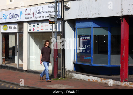 Young man walking past empty shops during recession in Camden Road, Tunbridge Wells, Kent, England Stock Photo