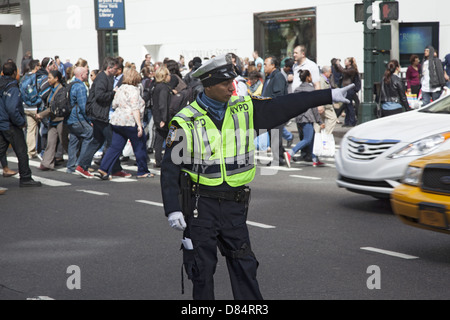 Traffic cop directs traffic at the always busy corner of 34th St. and 6th Avenue across from Macy's Dept. Store in Manhattan. Stock Photo