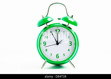 Picture of a green retro alarm clock on a white background with the clock five to twelve Stock Photo