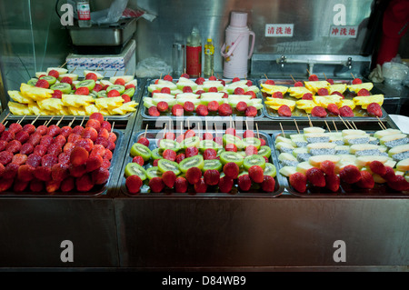 sticked fruits (Tanghulu or bingtanghulu) on food stall at Wangfujing Snack Street in Dongcheng District, Beijing, China Stock Photo