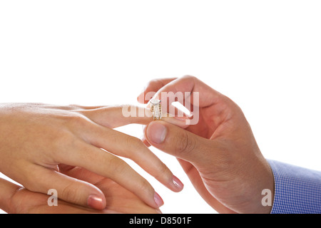 Horizontal photo with focus on male hand putting engagement ring on female hand isolated on white Stock Photo
