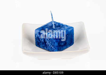 Blue candle on a plate isolated on a white background. Stock Photo