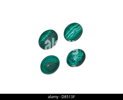 4 oval shaped malachite gems, isolated on a white background. It is a copper carbonate hydroxide mineral noted by its green band Stock Photo