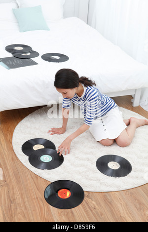 young woman sitting on floorm looking records. Stock Photo