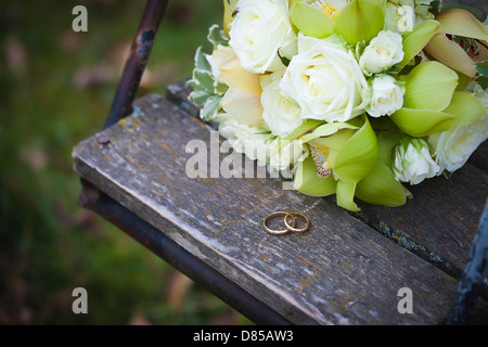 Wedding rings and white roses wedding bouquet Stock Photo