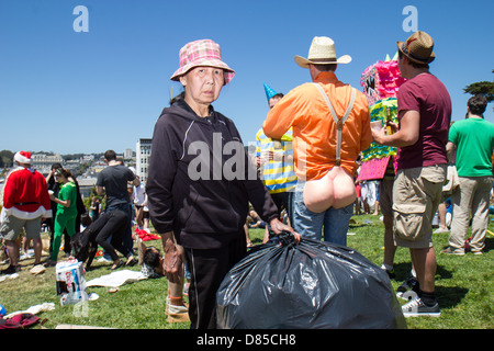 Woman collects empty cans and bottles during the 2013 Bay to Breakers festival.  San Francisco, CA. 5/19/2013 Stock Photo