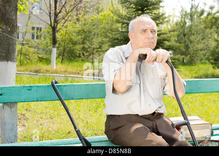 Portrait of old man sitting on the bench park waiting for someone Stock Photo