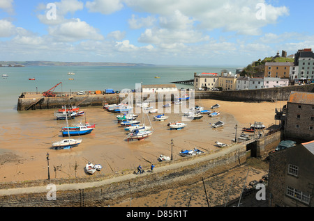 Small boats lie stranded on the sand in Tenby Harbour, West Wales, UK, at low tide. Stock Photo