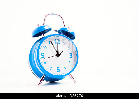 Picture of a blue retro alarm clock on a white background with the clock five to twelve Stock Photo
