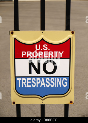 A sign posted on a fence that reads ' US Property No Trespassing' Stock Photo