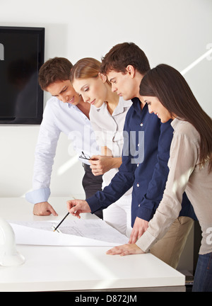 Architects team working on construction drawing in their office Stock Photo