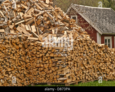 A large pile of chopped wood in front of Swedish house  prepared for winter heating Stock Photo