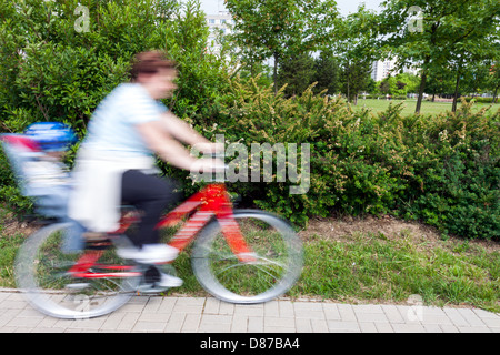 woman with child on bicycle - panning image Stock Photo