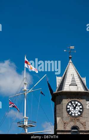 Guernsey flag on flag pole mast and modern seafront buildings ST PETERS PORT GUERNSEY Stock Photo