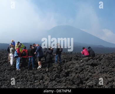 Tourists hike to the summit of Mount Etna near Catania, Sicily, Italy, 09 May 2013. A cable car takes passengers to a height of around 2,000-2,500 meters where people can transfer to busses or hike up to around 3,000 meters. With a height of 3,323 meters, Mount Etna is Europe's tallest and most active volcano. Photo: JENS KALAENE Stock Photo