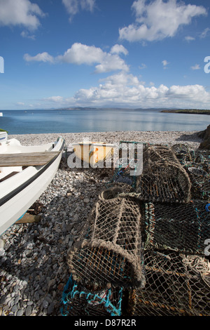 The Wales Coastal Path in North Wales. Picturesque view of fishing boats and lobster pots on Moelfre beach. Stock Photo