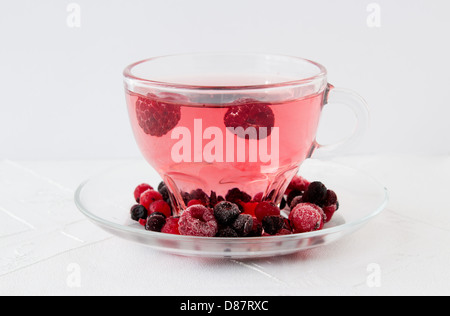 Red drink from mixed berries in trasparent cup decorated with frozen berries. Stock Photo