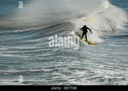 Jacksonville Beach surfer riding a wave on the south side of the Jacksonville Beach Pier in Northeast Florida. (USA) Stock Photo