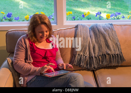 Woman using ipad in living room Stock Photo