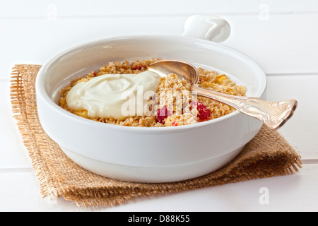 Apple and Raspberry Crumble - an individual serving of apple and raspberry crumble, topped with healthy olive oil crumble and... Stock Photo