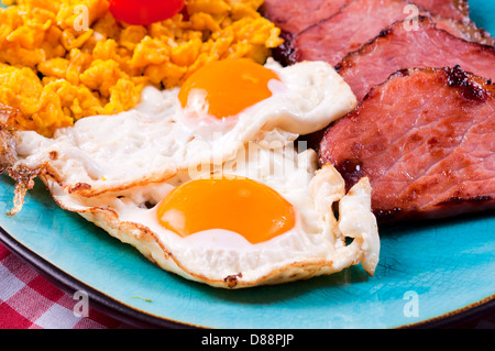 Strong breakfast with eggs and ham. Selective focus on the ham and eggs Stock Photo