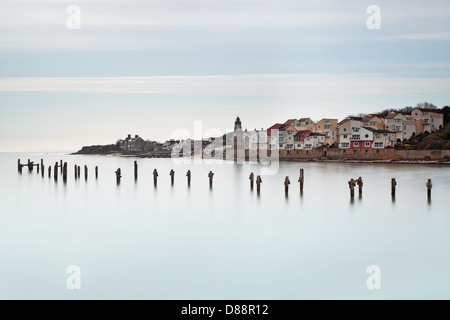 The old pier at Swanage in Dorset looking across towards Peveril Point with the houses, clock tower and lifeboat station. Stock Photo