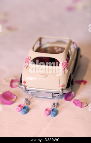 Just married, a toy car dressed as a wedding car complete with tin cans and confetti as an illustrative picture Stock Photo