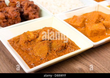 Thali - Indian meal set with vegetarian and meat curries, pilau rice and onion bhajis. Stock Photo