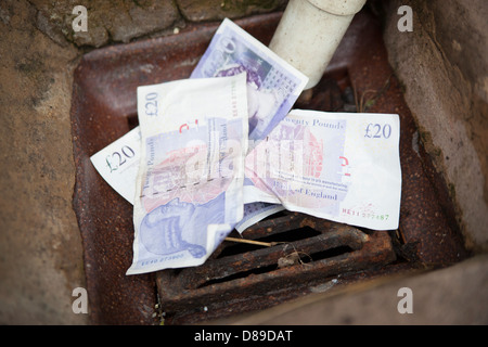 Throwing money down the drain. Stock Photo