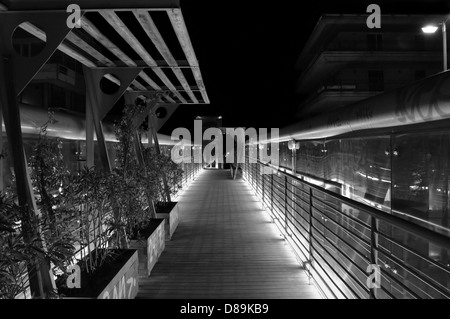 Pedestrian overpass metal bridge above the motorway at night. Black and white. Stock Photo