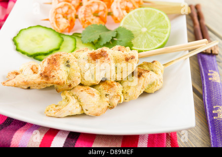 Sate Gai & Sate Goong - Thai chicken and prawn satays served with cucumber and onion relish and peanut sauce. Stock Photo