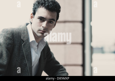 Man in twenties in tweed jacket and white shirt looks serious. Stock Photo