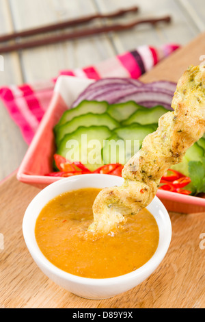 Sate Gai - Thai chicken satay served with peanut sauce, sliced onions chilies and cucumber. Stock Photo