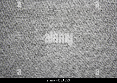 This fabric is a gray heather knit, often used for comfortable t-shirts and casual wear. The texture of the fabric is soft and breathable, providing both comfort and flexibility. The heathered pattern, created by blending different shades of gray, adds depth and visual interest to the fabric while maintaining a versatile, neutral tone suitable for various clothing styles. Stock Photo