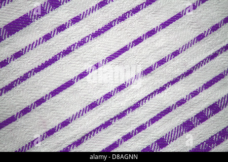 This fabric features a design of purple and white diagonal stripes, with a smooth, evenly spaced pattern. The contrast between the purple and white adds visual appeal, making it suitable for various design purposes. Stock Photo