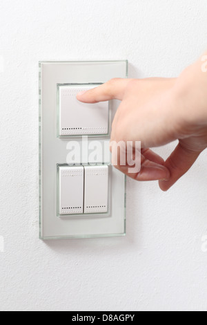 Woman hand operating a light switch Stock Photo