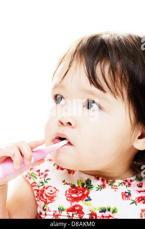 Little girl brushing her teeth with pink toothbrush Stock Photo