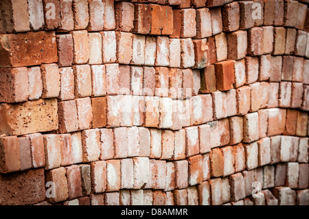 New red brick pavers stacked in rows like wall. Store of bricks ready for building or sale. Construction materials and outdoor Stock Photo