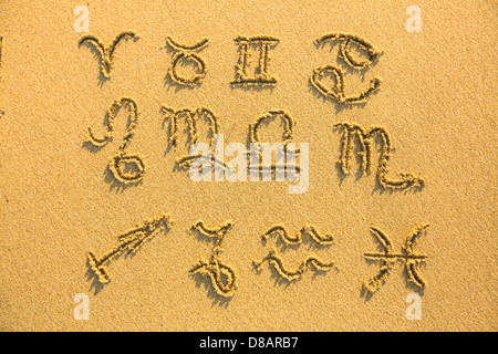 Set of zodiac signs - drawn on the facture beach sand. Stock Photo