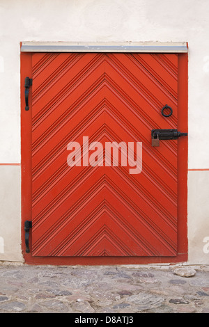 Small Red wooden door with lock in old building facade. Tallinn, Estonia Stock Photo