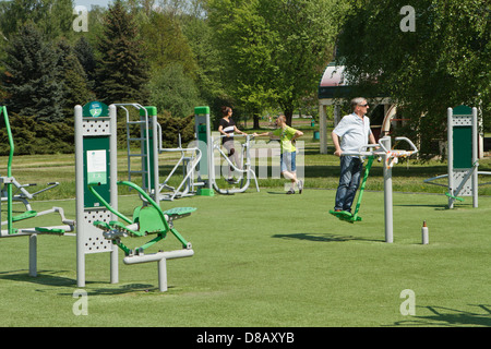 People using outdoor gym equipment in a public park. Stock Photo