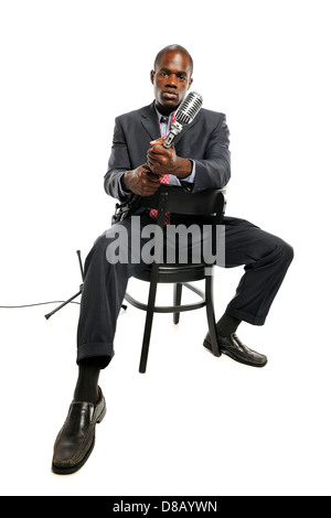 African American Man holding a vintage microphone isolated on a white background Stock Photo