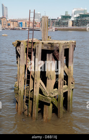 Remains of a wooden jetty structure on the River Thames in Rotherhithe, London, SE16, UK. Stock Photo