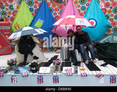 London, UK. 24th May 2013. Stallholders put on a brave face despite the heavy but intermittent rain showers at the Chelsea Flower Show. Stock Photo