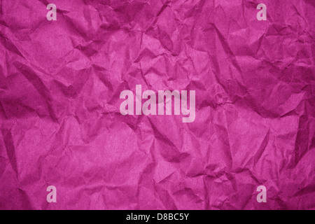A close-up of crumpled fuchsia paper, displaying a wrinkled and textured surface. The vivid fuchsia color stands out against the creases, creating a dynamic and abstract visual effect. This image highlights the tactile nature of paper and its ability to transform visually through texture. Stock Photo