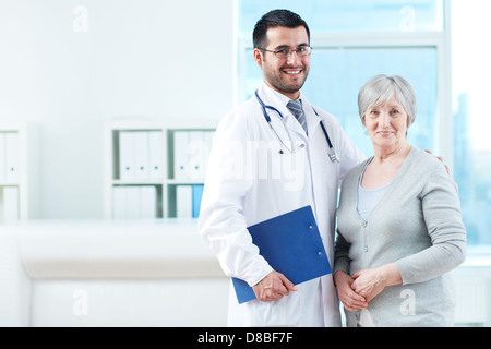 Senior patient and successful doctor looking at camera in hospital Stock Photo