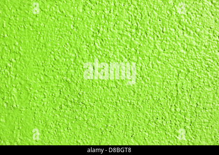 A textured close-up of a lime green painted wall, showing the smoothness and depth of the paint finish. The bright color adds vibrancy and energy to the space, commonly used in modern interior design. Stock Photo