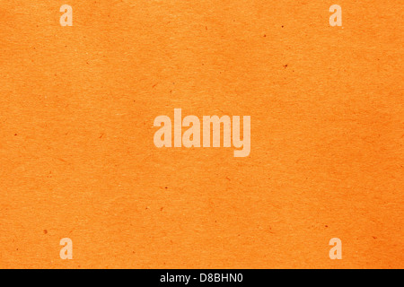 A close-up image of orange-colored paper with small flecks visible throughout the surface. This textured paper can be used for various craft projects and artistic purposes. Stock Photo